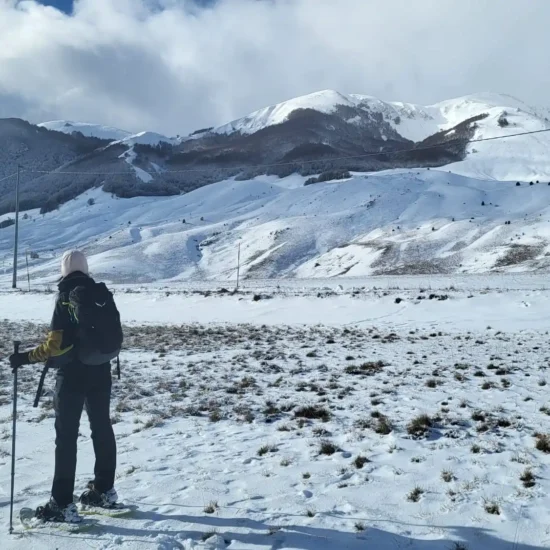 Escursionista sullo sfondo dell'Altopiano innevato dell'Aremogna a Roccaraso