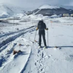 Escursionista sullo sfondo dell'Altopiano innevato dell'Aremogna a Roccaraso